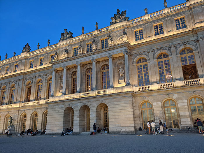 Voyages-Deci-Dela-vue-exterieur-du-chateau-de-Versailles-au-soleil-couchant