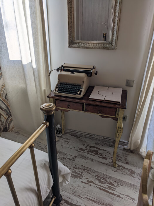 Voyages-Deci-Dela-superbe-Hotel-cosy-à-Galaxidie-Ganimede-Aperçu-de-l'interieur-de-la-chambre-machine-à-ecrire-pour-les-ecrivains-en-herbe